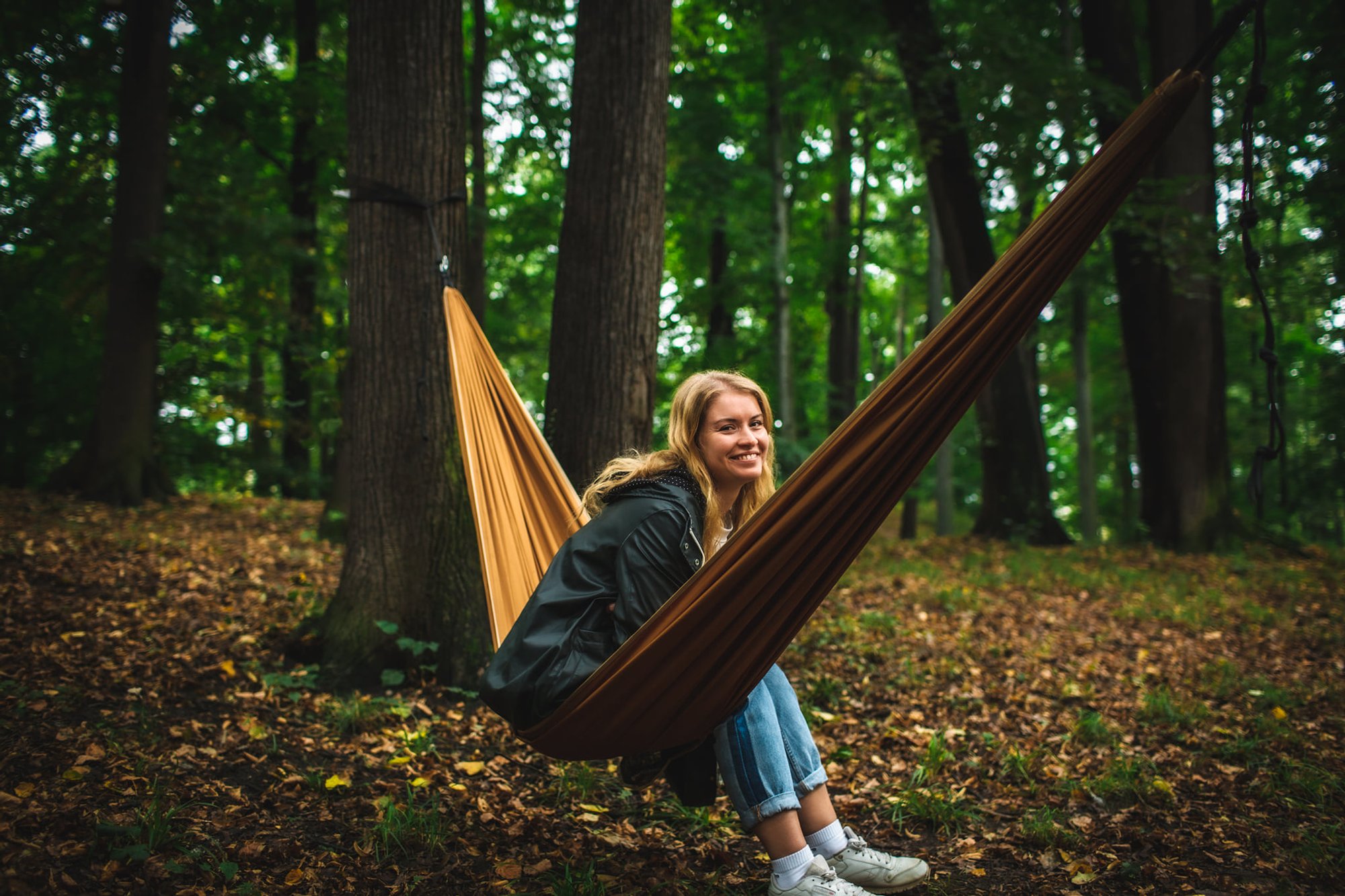 Młoda kobieta siedzi na hamaku, rozwieszonym między drzewami w parku. Szeroko uśmiecha się do obiektywu. To Agnieszka Kozak, prowadząca spotkania.