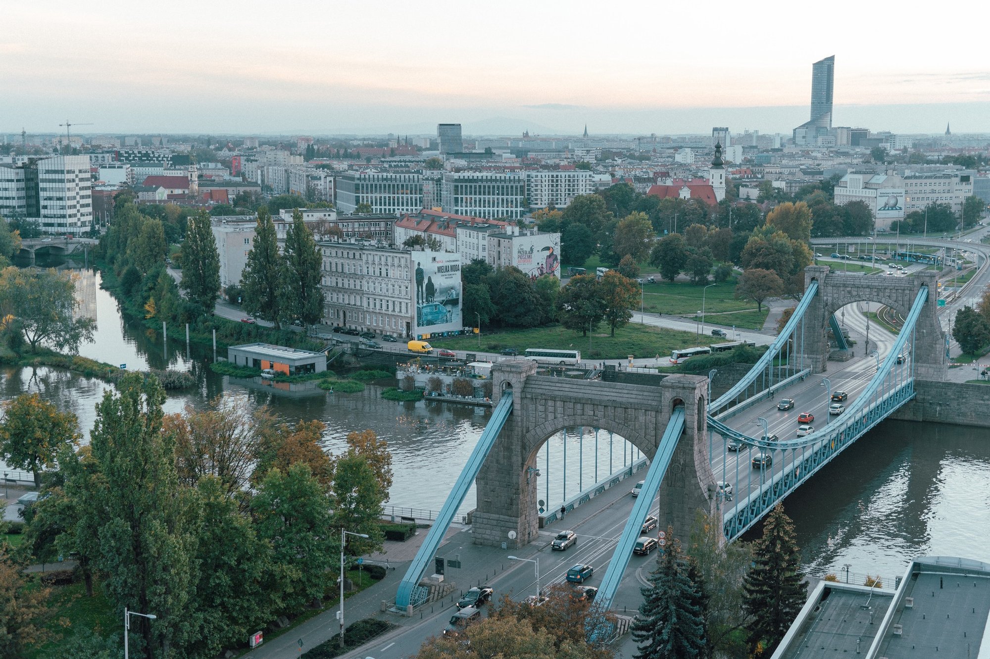 Kolorowa, pozioma fotografia przedstawiająca widok z lotu ptaka na most Grunwaldzki oraz część miasta. 