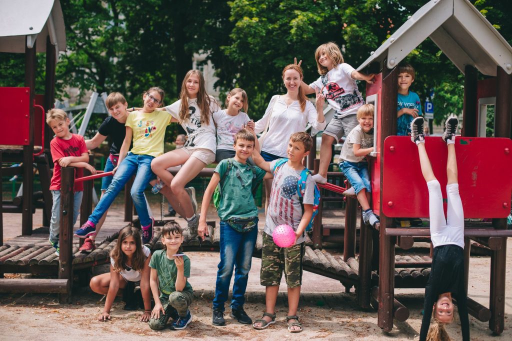 zdjęcie: Marta Sobala Kolorowa fotografia przedstawia grupę dzieci pozujących do zdjęcia na placu zabaw.