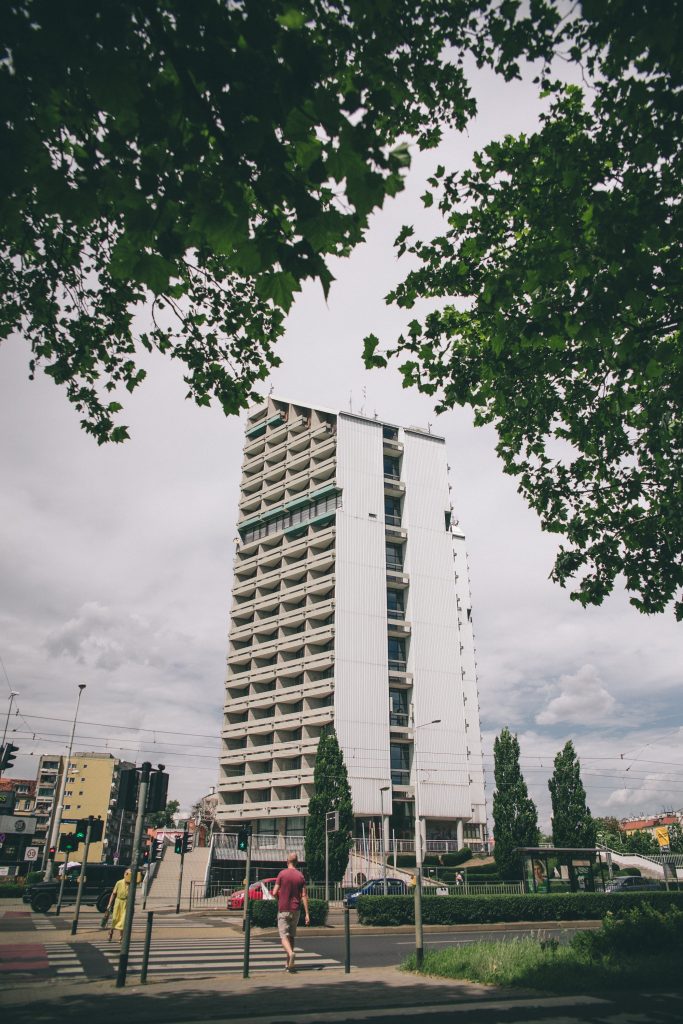 Widok na wrocławski akademik "Ołówek" oraz ulicę biegnącą przed nim.
