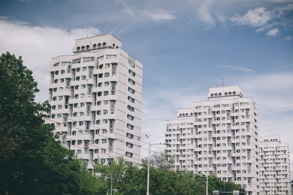 Kolorowa, pozioma fotografia przedstawia wrocławski Manhattan i charakterystyczne budynki z okrągłymi oknami.