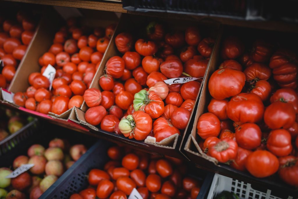 Zbliżenie na kosze wypełnione pomidorami.