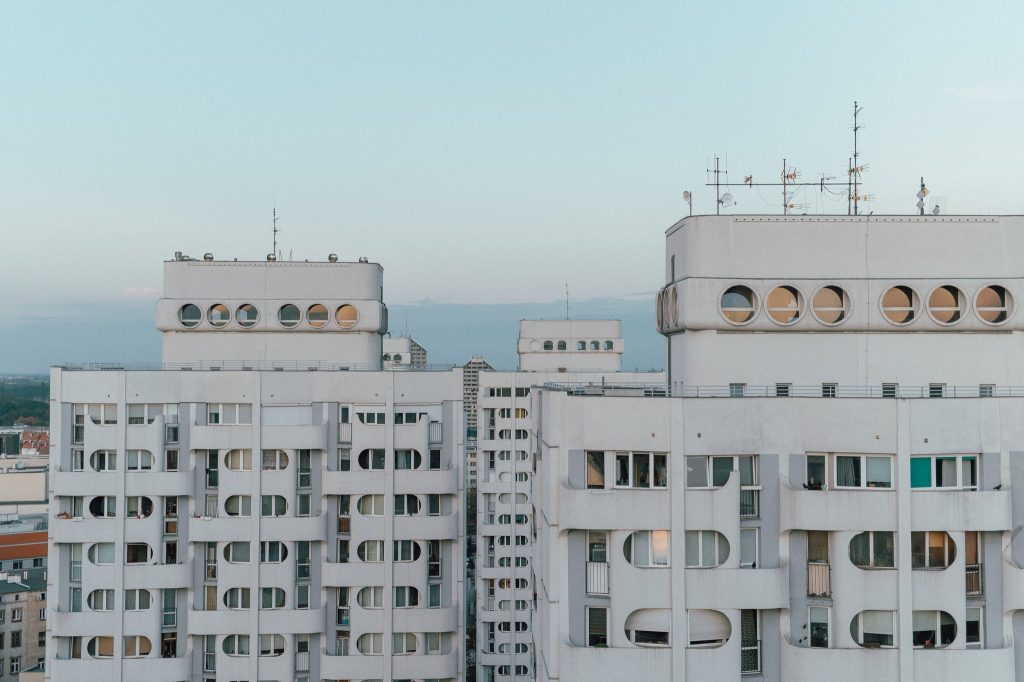 Kolorowa, pozioma fotografia przedstawia widok na szczyty bloków kompleksu Manhattan.