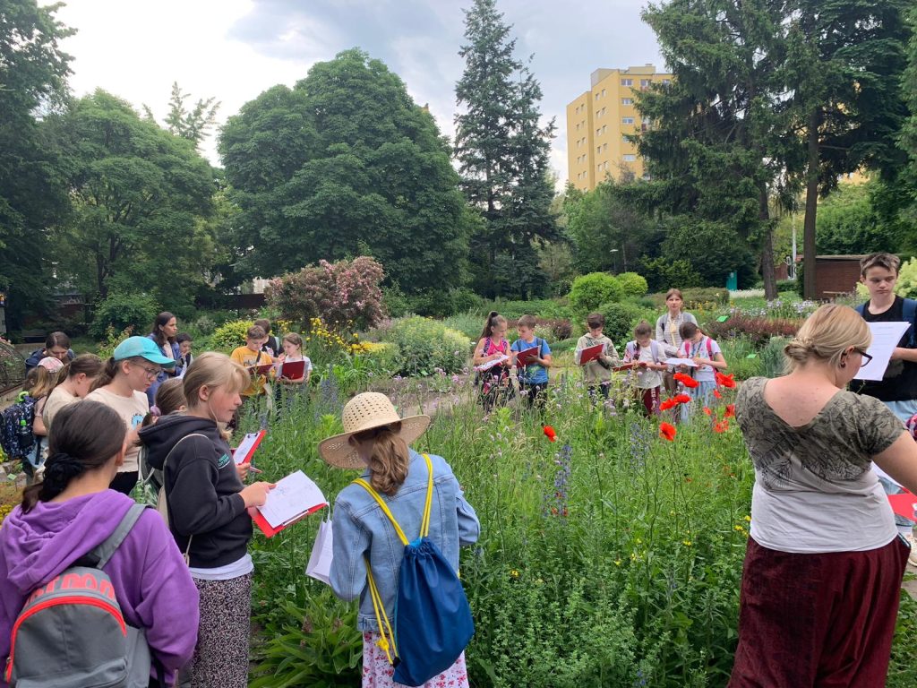 Grupa młodzieży spaceruje po ogrodzie botanicznym.