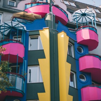 Plomba architektoniczna wybudowana w 1996 roku według projektu architekta Wojciecha Jarząbka. Nazywana także “Papugowcem”. Charakterystyczna elewacja składa się z geometrycznych i prostokątnych elementów, a także przeszklonych balkonów. Fotografia pochodzi z okresu po odnowieniu budynku, gdy pierwotny kolor czerwonego wina zastąpiono różowym.